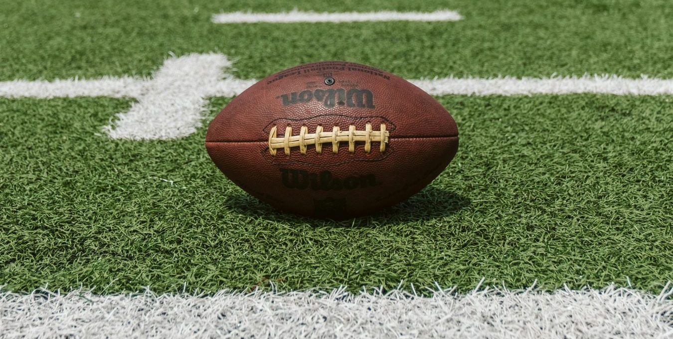 an american football sits on the field at The Maxwell